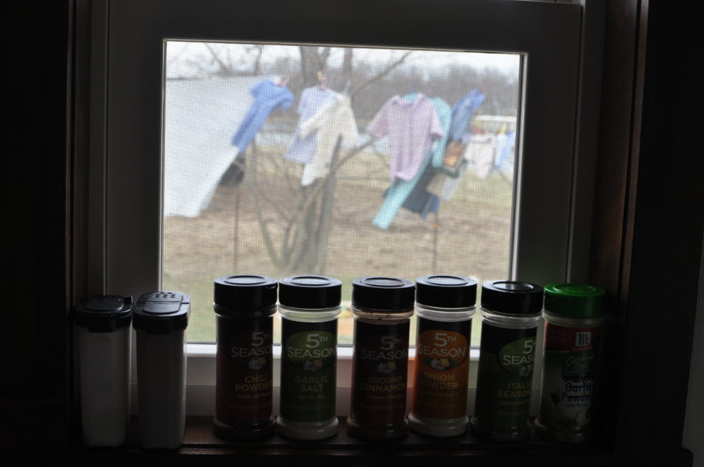 a small selection of Gloria's favorite seasonings sit on her windowsill