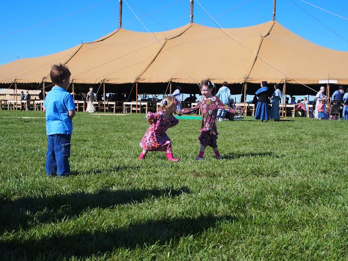 Children play on the grounds of the Annual Meeting.  The big tent in the background is where services and meetings ar